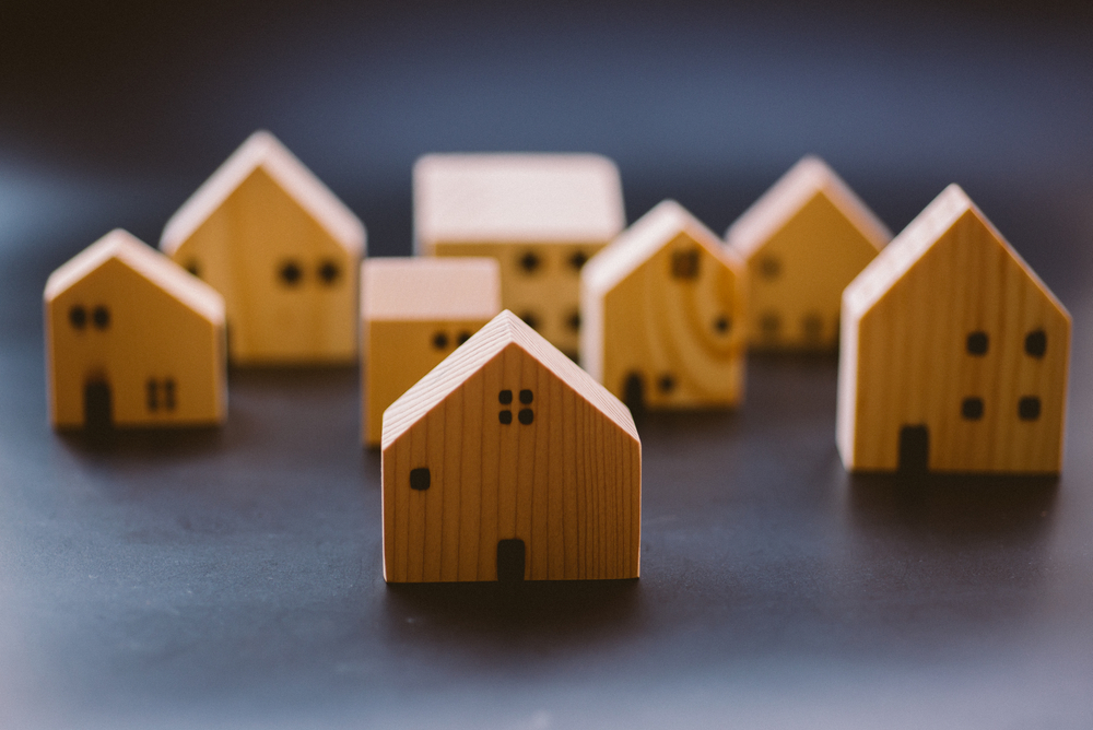 Miniature,Wooden,House,Models,Arranged,Together,,Symbolizing,Real,Estate,,Housing